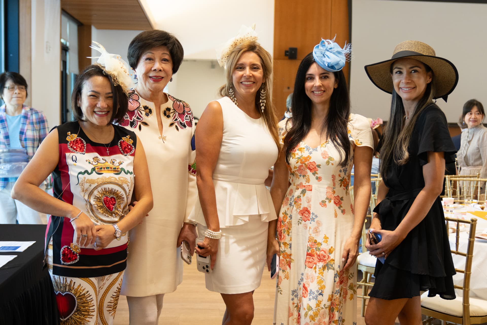 Guests in hats and fascinators posing together at the high tea